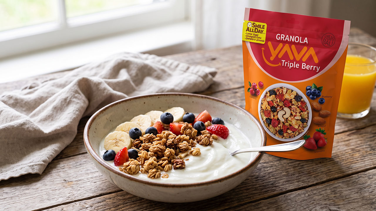 Semangkuk yoghurt dengan topping Granola YAVA dan potongan buah segar, disajikan di samping kemasan granola.