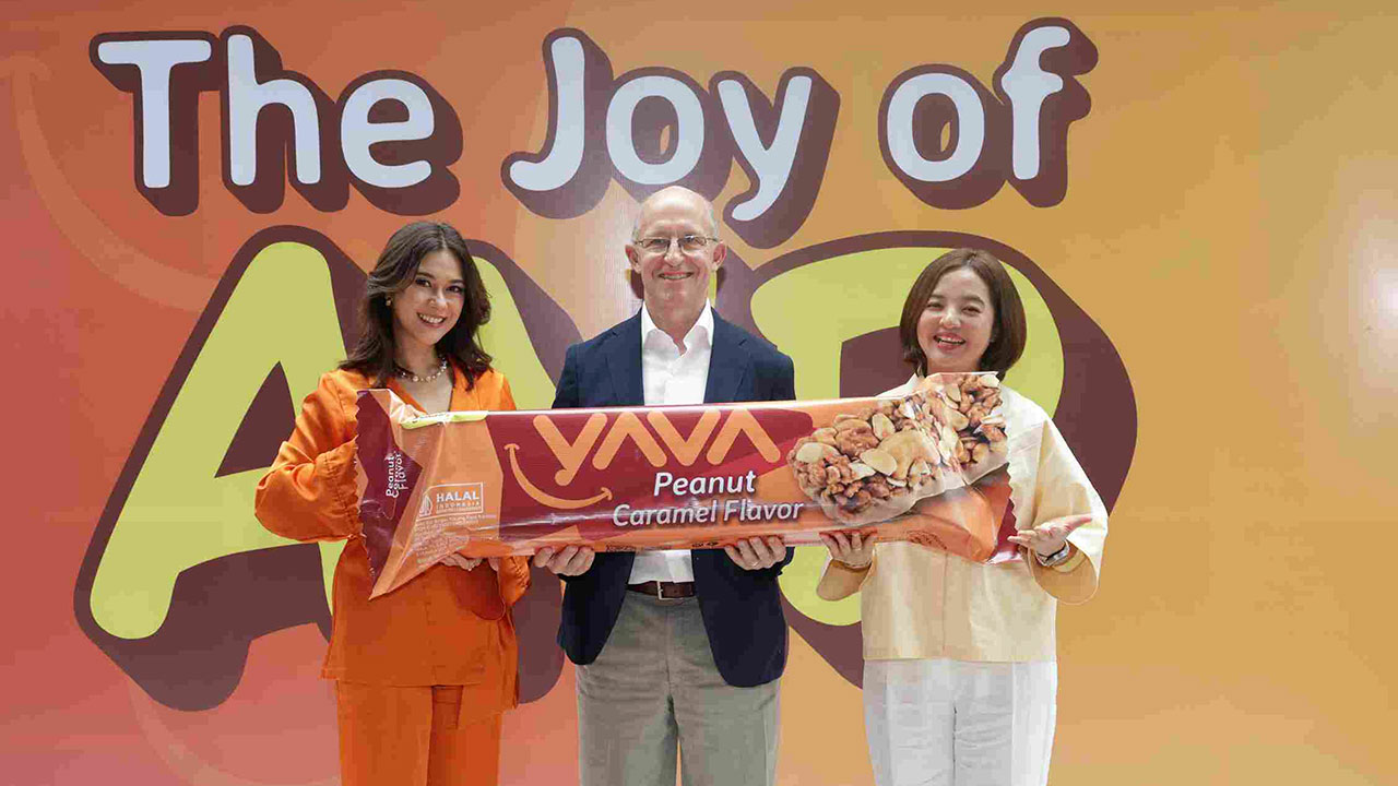Tiga orang berfoto dengan produk YA’Bar Peanut Caramel Flavor di depan backdrop The Joy of AND.