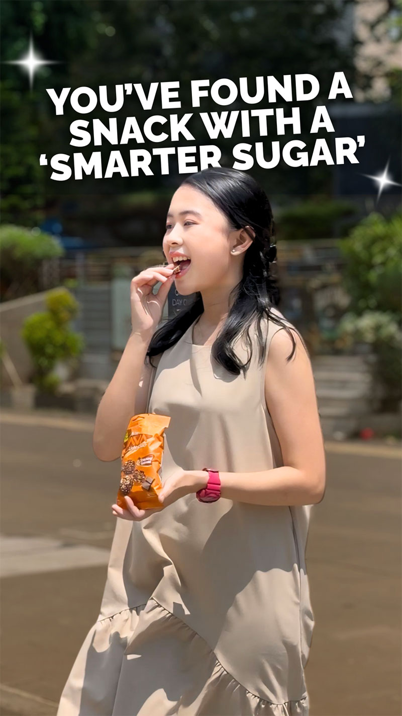 Tangan memegang kemasan YAVA Granola Bites Chocolate Vanilla di rak toko.